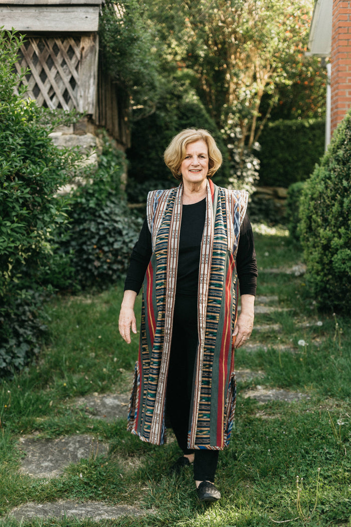 Woman walking outdoors in panel coat. Coat is made with woven Ikat fabric.