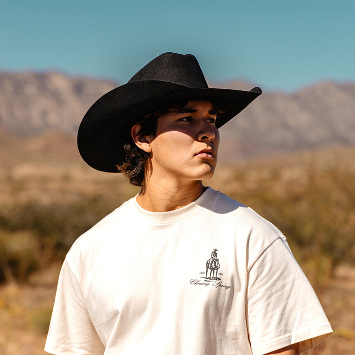 Adult model wearing white graphic tee with “Bat and Bridle Relaxed” design