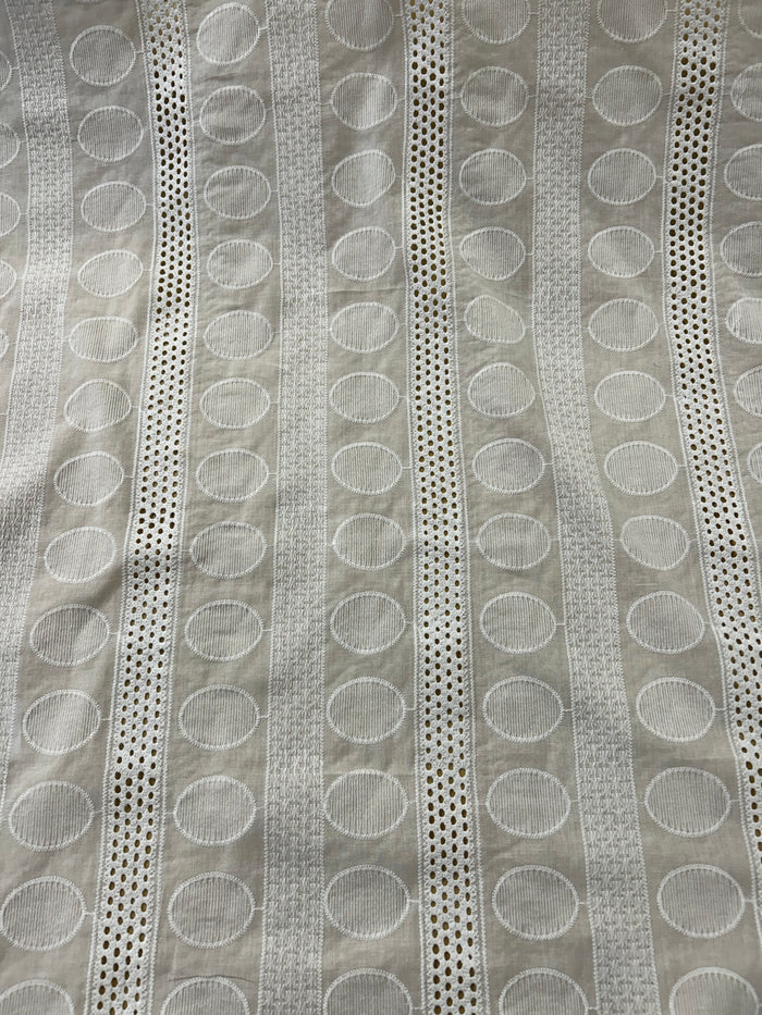 Close-up of a textured fabric with circular patterns and stripes.