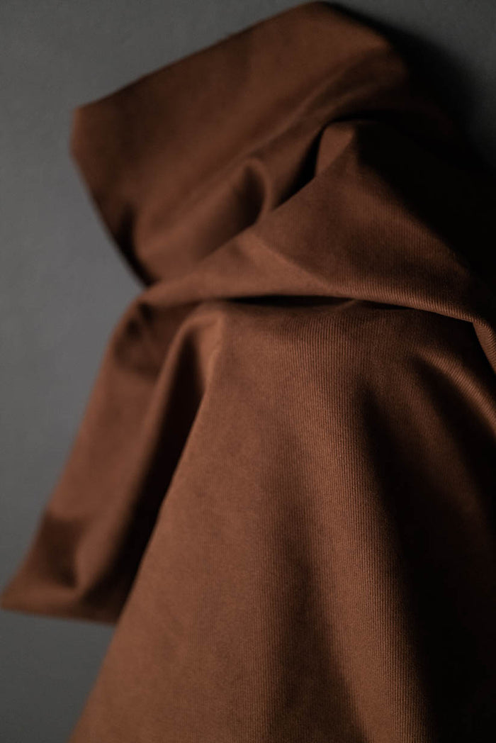 A bolt of tobacco brown cotton sanded twill fabric.