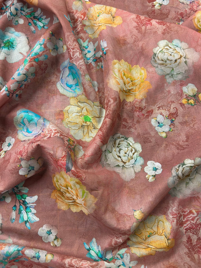 Draped floral patterned fabric with peonies/roses of white, yellow, and blue on a pinkish-brown background.