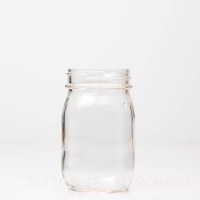 Vintage regular mouth pint mason jar with FL 16 oz imprinted near the rim, against a white background