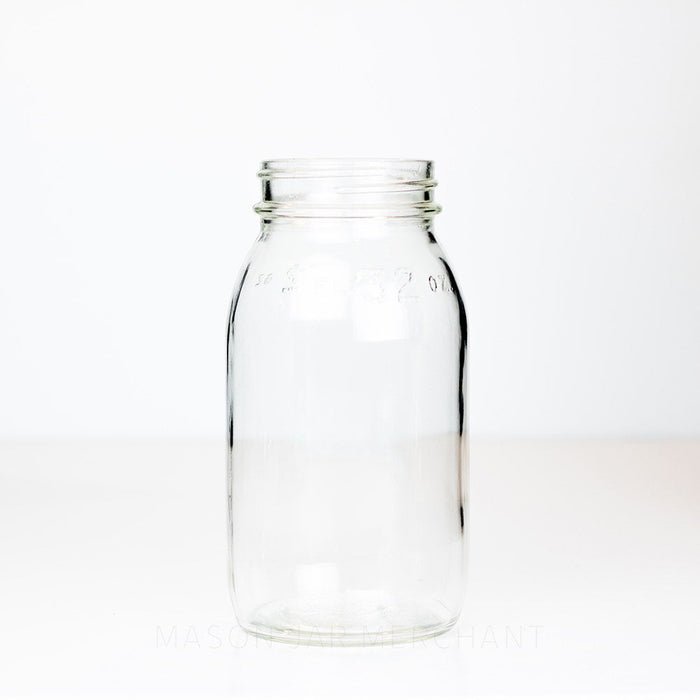 A 7 1/8 inches tall without lid regular mouth mason jar on a white background