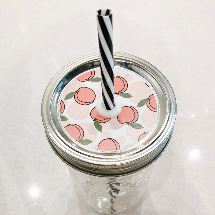 Photo of a peach mason jar straw lid with a black and white straw