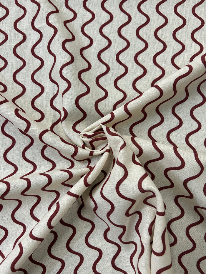 Wavy red stripe pattern on a beige background in a swirl.