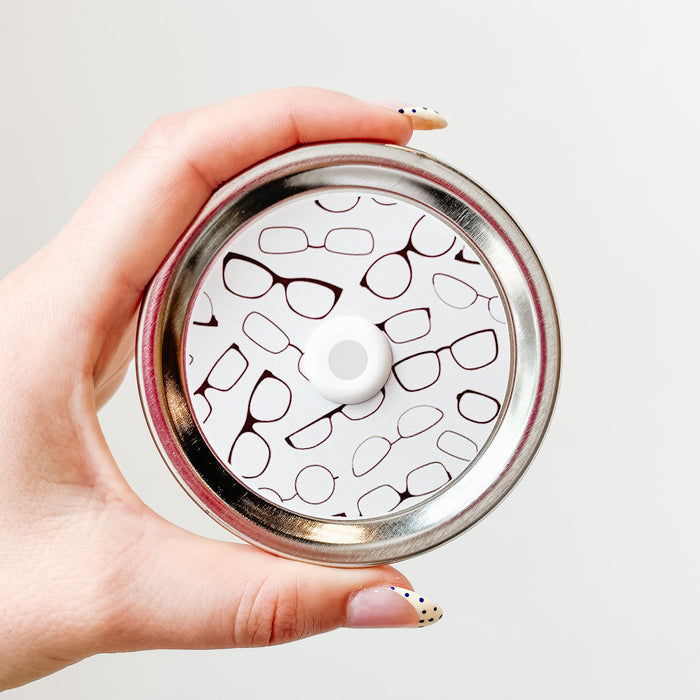 straw lid with white background and different reading glasses across it