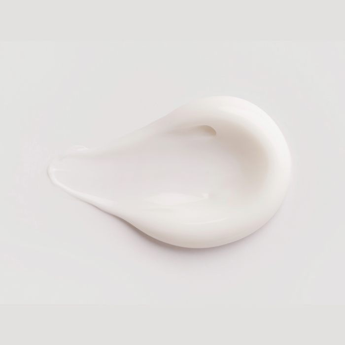 SKN015 SKNLOGIC Eye Cream Age Defense with antioxidants 15ml | A smooth, glossy smear of thick white eye cream shaped like a teardrop, on a clean, light gray background.