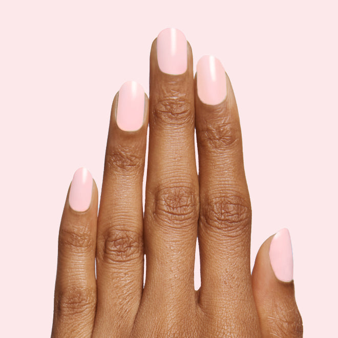 Hand with soft pale pink manicure showcasing at-home mani using The Pink Mama Set by Olive and June