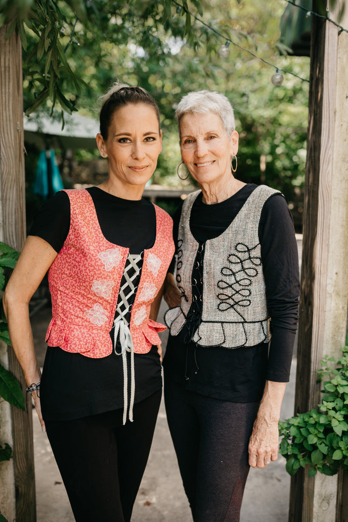 Two women standing side by side outdoors in Polish Vests.