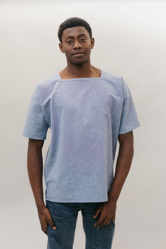 Young African American man standing in front of a white studio backdrop wearing the square neck 211 Two Middies.