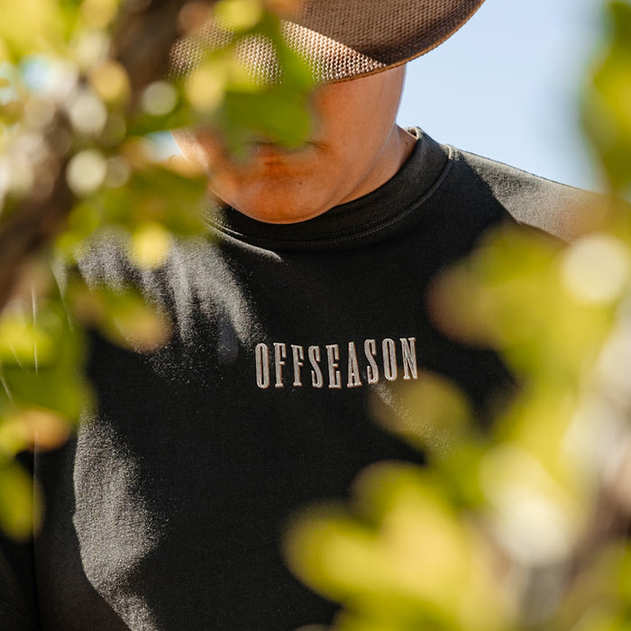 Youth model wearing black youth graphic tee with “Backstop Range Relaxed” design