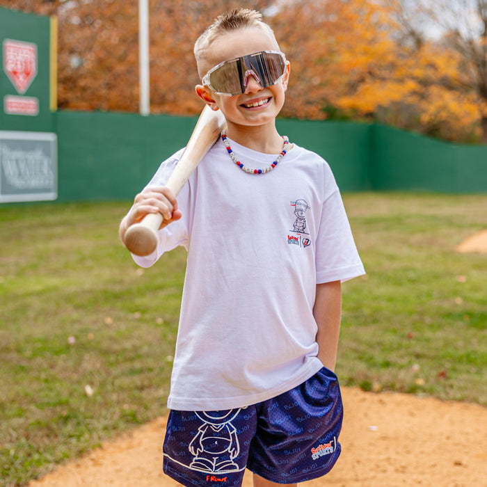 Youth model wearing white youth graphic tee with “Backyard Blueprint” design