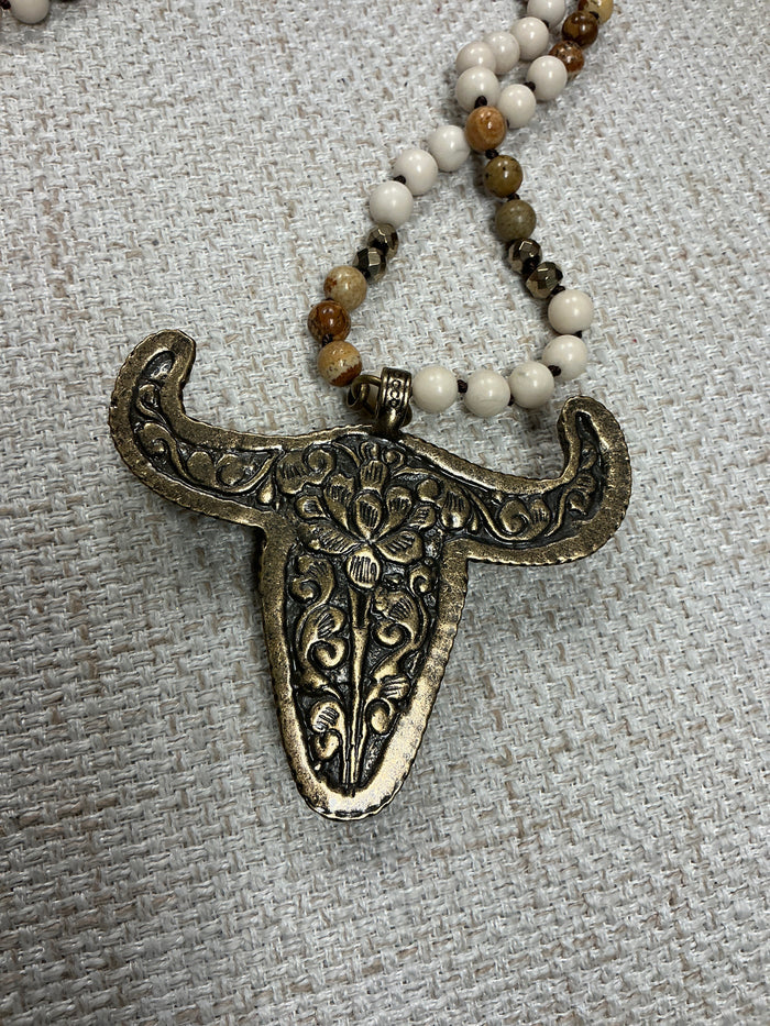 Beaded cow skull talisman necklace featuring intricate beadwork and a rustic cow skull pendant, crafted by American Unique Group.