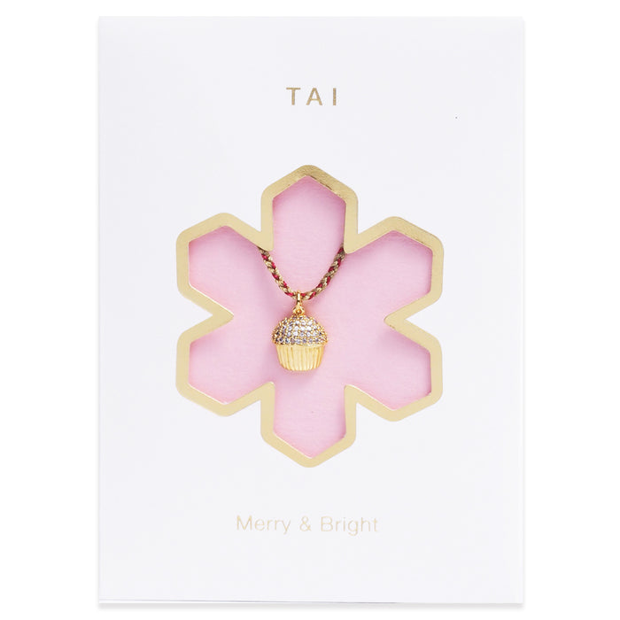 Gold-tone cord necklace featuring a cupcake charm pendant