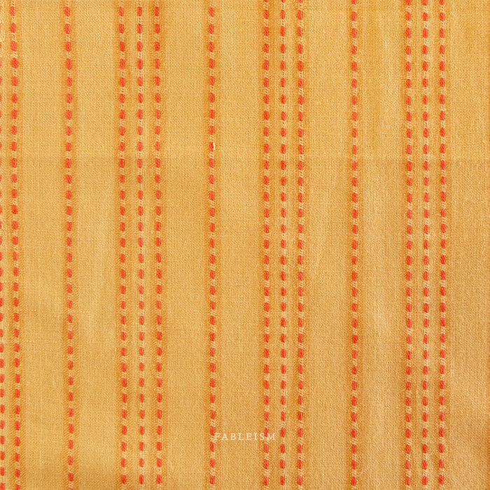 Textured fabric with orange vertical stripes on a beige background