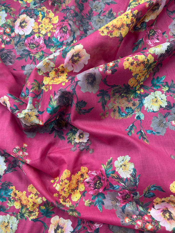 Cotton voile fabric with a vibrant and unsaturated floral print with white, burgundy and yellow flowers on a maroon background