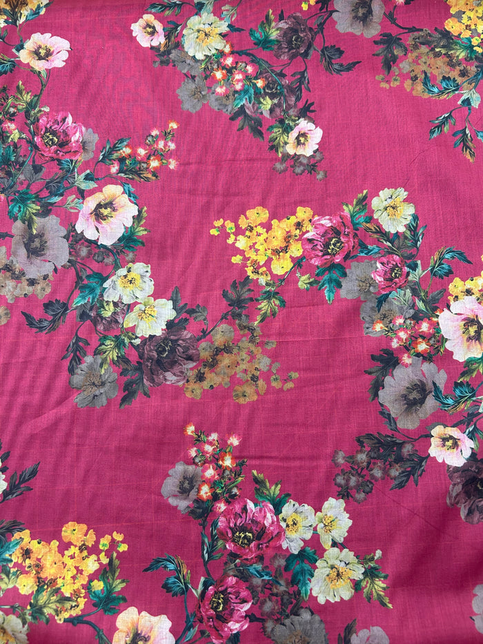 Cotton voile fabric with a vibrant and unsaturated floral print with white, burgundy and yellow flowers on a maroon background