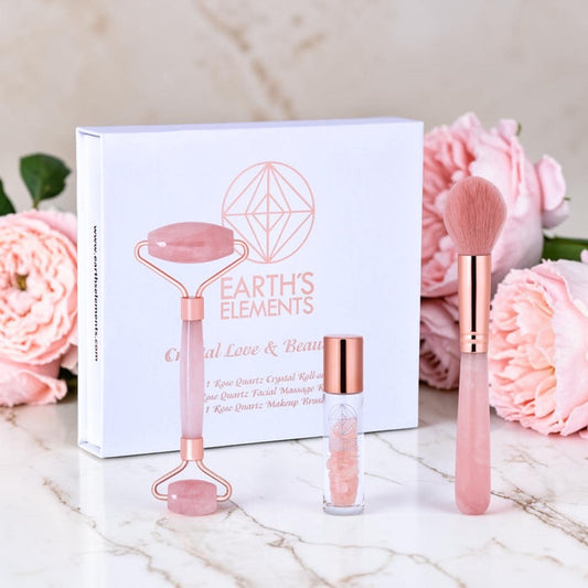 Beauty tool set with roller, brush, and bottle in front of 'Earth's Elements' packaging with pink flowers in the background.