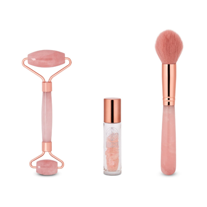 Set of skincare tools including a roller, bottle, and brush on a white background