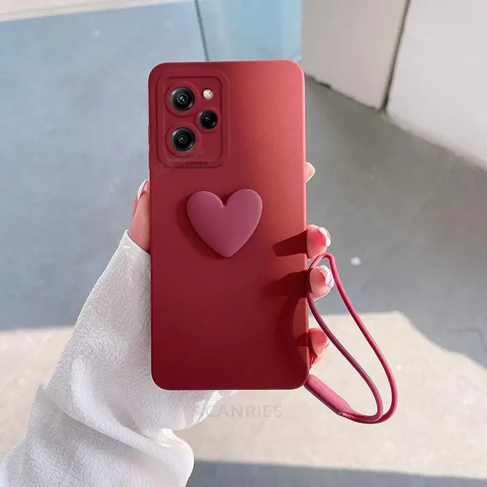 a person holding a red phone case with a heart on it