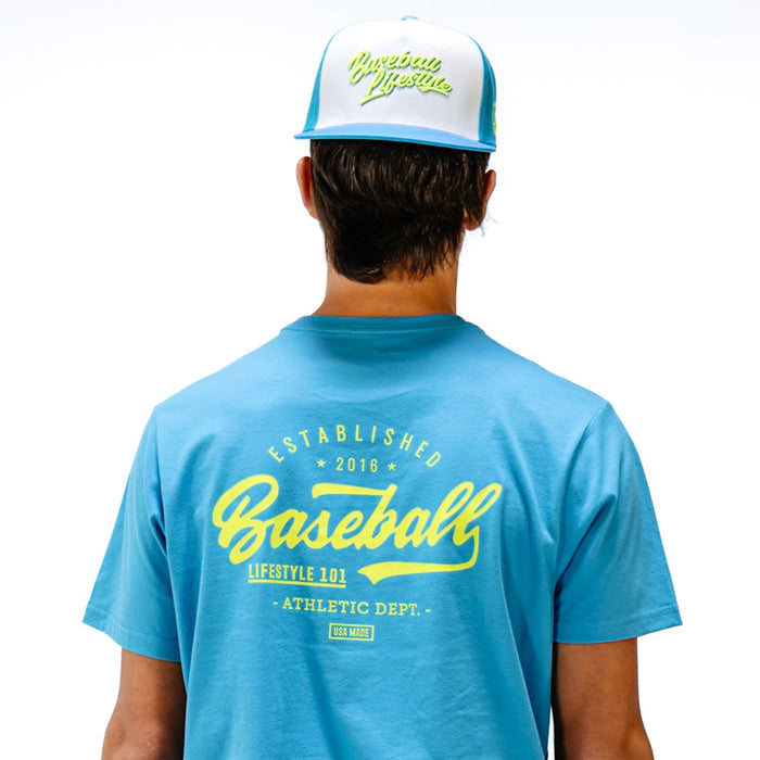 Person wearing a blue t-shirt with yellow text that says 'Baseball Lifestyle 101' and a white and blue cap