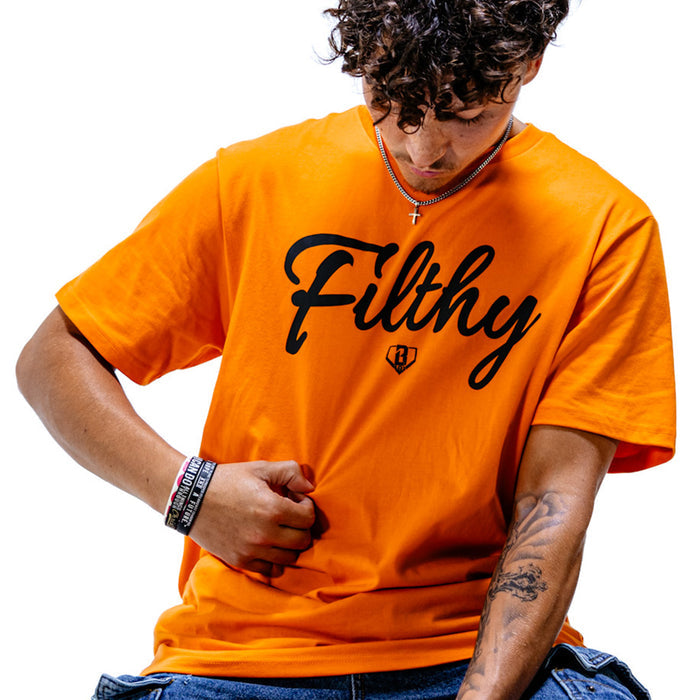 Person wearing an orange t-shirt with 'Filthy' printed on it against a white background
