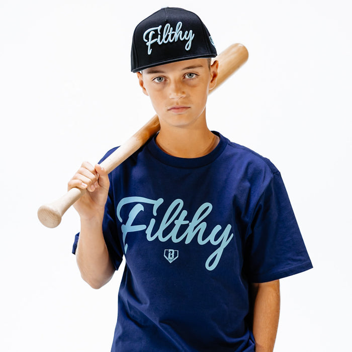Child wearing a navy 'Filthy' t-shirt and cap, holding a baseball bat on a white background