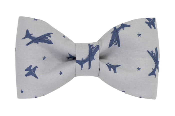 Adventure ready dog bow tie featuring a navy blue airplane and star pattern on a light gray background—perfect for pups on the go.