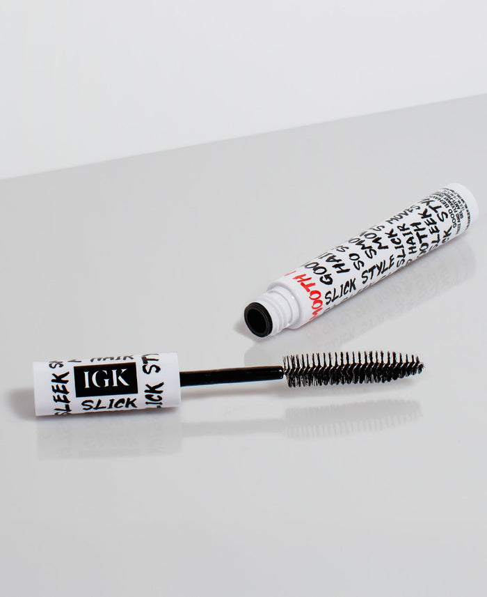 XL Taming Wand with black brush and white cylindrical container on a light gray background