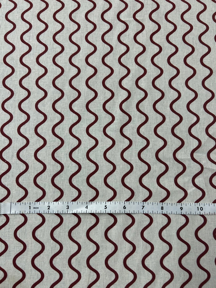Wavy red stripe pattern on a beige background. and a ruler for scale.