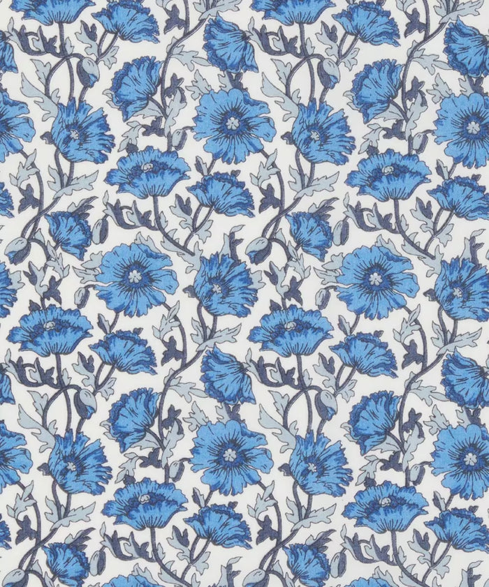 Close up of Liberty of London cotton tana lawn in a  beautiful, vibrant print of blue poppies with a white background.