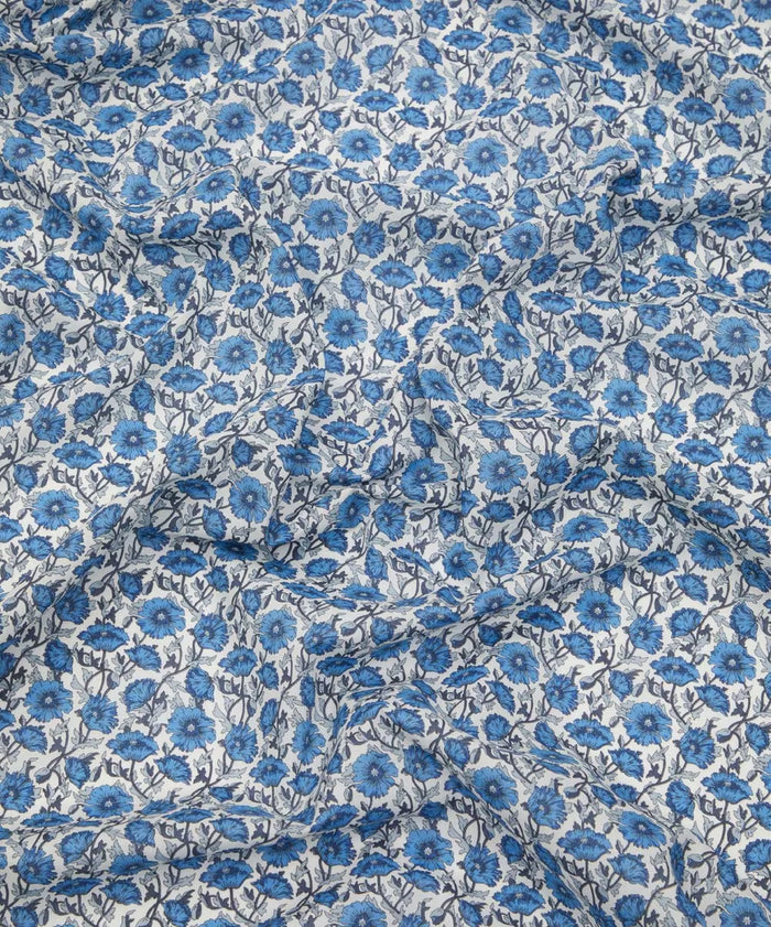 Liberty of London cotton tana lawn in a  beautiful, vibrant print of blue poppies with a white background.