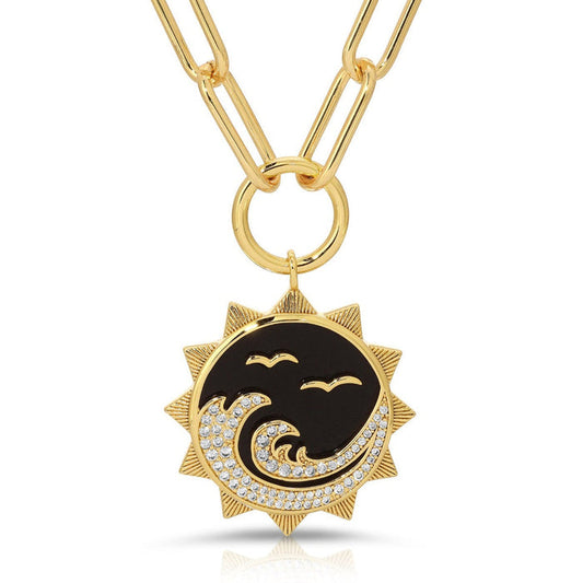 Gold-tone sun pendant with black onyx-style enamel and crystal accents on chain