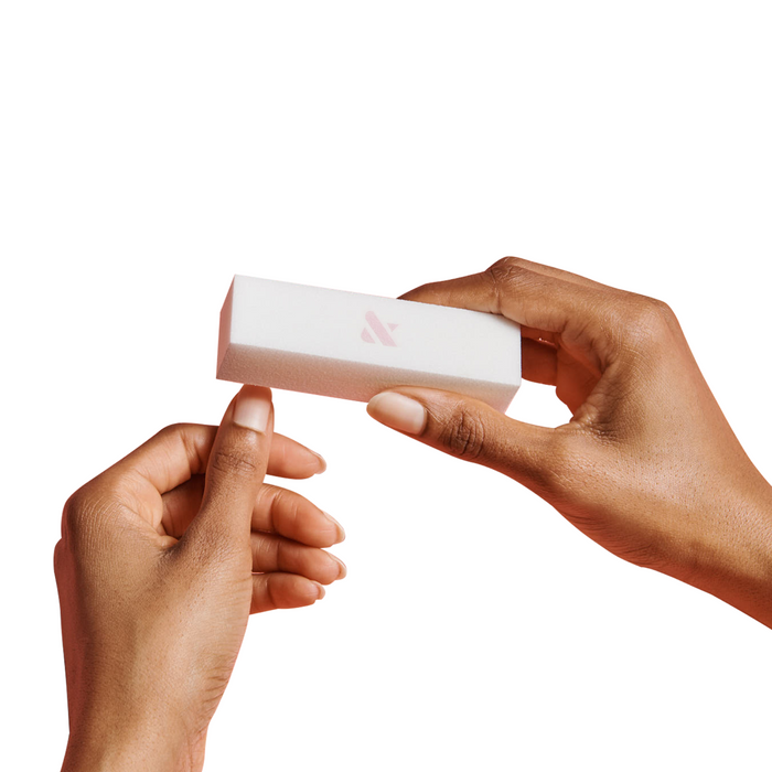 Hands using a white buffer block on natural nails as part of the Mani Prep Set for manicure preparation
