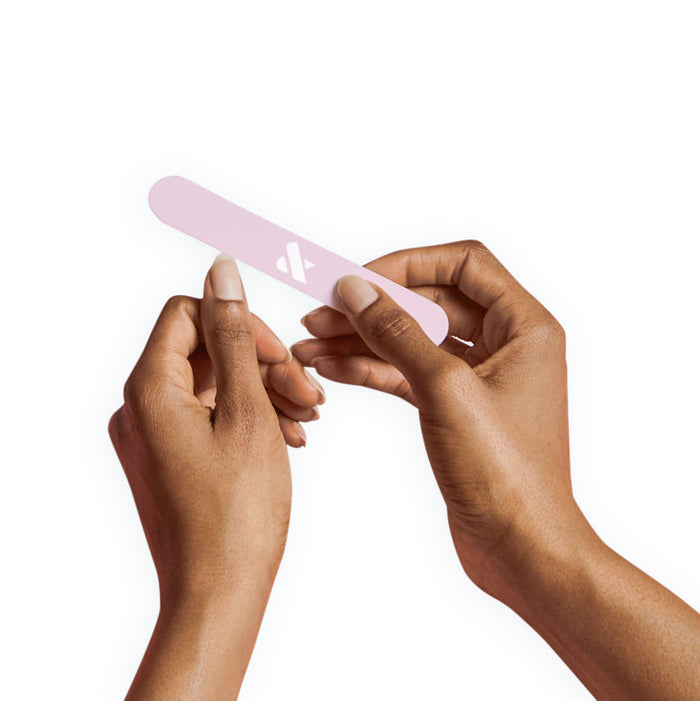 Hands filing nails with a pink nail file as part of the Mani Prep Set for a smooth manicure base