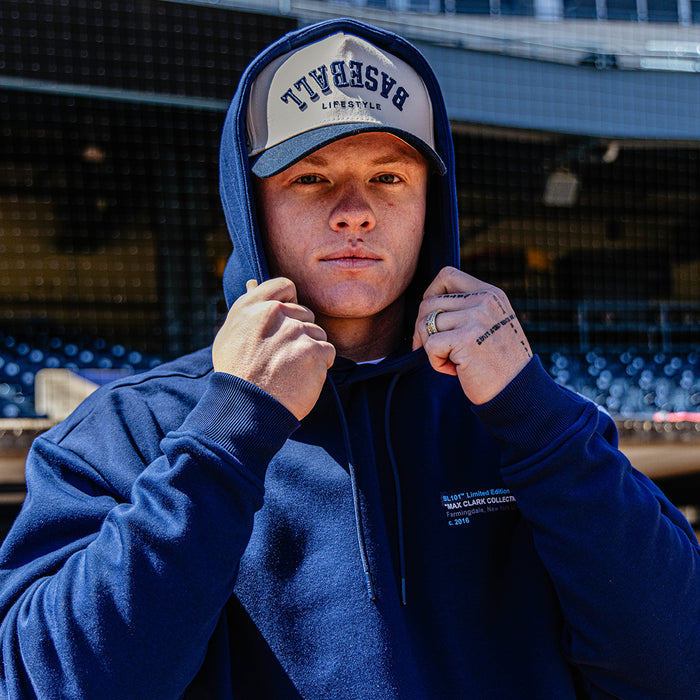 Person wearing a blue hoodie with a visible brand logo, standing in an indoor sports facility.