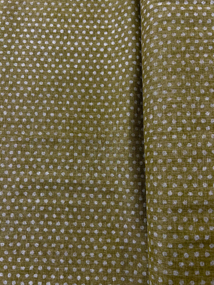 Close-up of green fabric with a subtle polka dot pattern