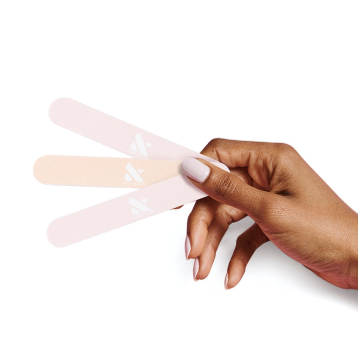 Hand holding three pastel nail files from the Nail File Pack for shaping nails in at-home mani and pedi care