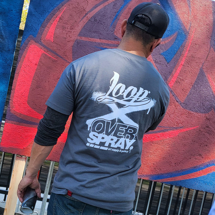 Person wearing a 'Loop Over Spray' t-shirt in front of a colorful mural.