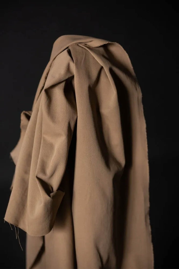 tan fabric roll against a black wall
