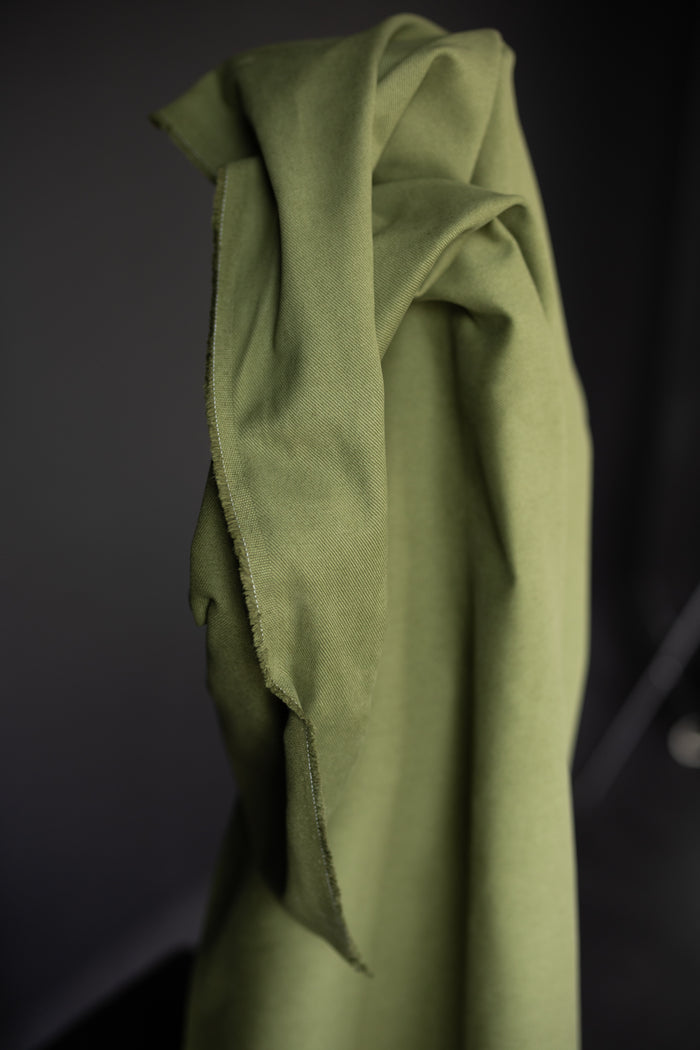 12 oz sanded twill fabric in a spring green on a dark grey background.