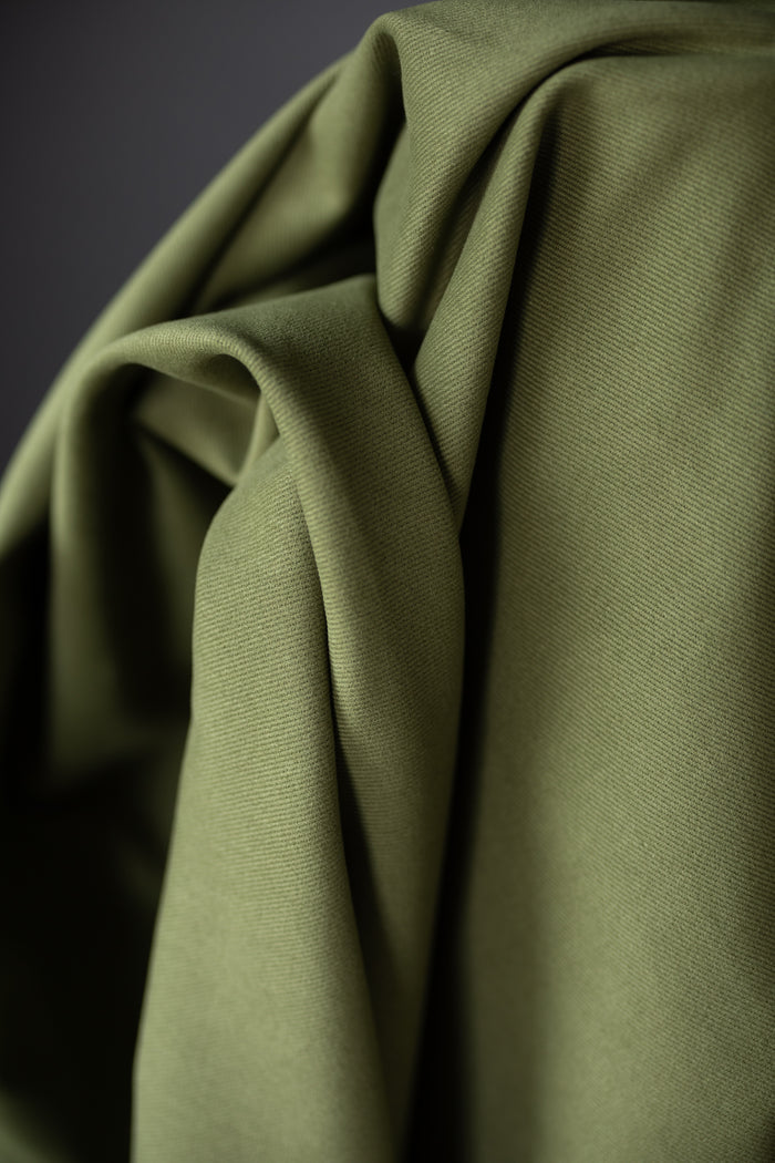 12 oz sanded twill fabric in a spring green on a dark grey background.