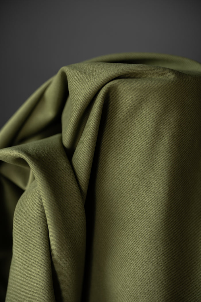 12 oz sanded twill fabric in a spring green on a dark grey background.
