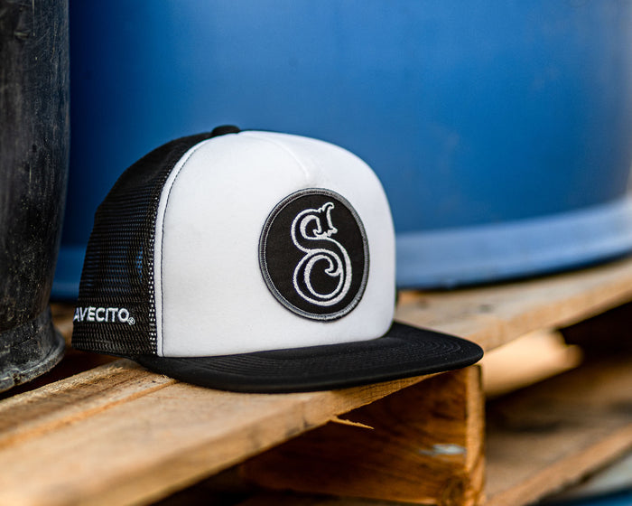suavecito hat with white embroidered text and black background with suavecito "S"