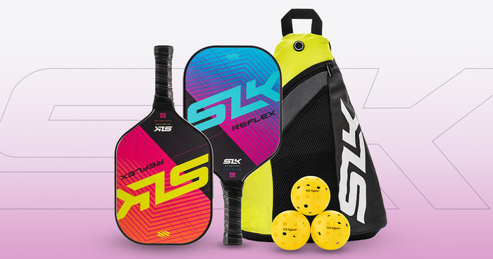 Two colorful pickleball paddles labeled SLX REFLEX, three yellow practice balls, and a black-and-yellow carrying bag.