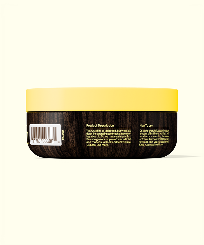 Back of a hair product container with yellow lid and black body on a white background