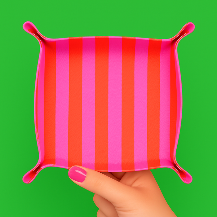 Pink and orange striped Aspen Lane trinket tray with a smooth surface and curved edges, ideal for jewelry or small accessories.