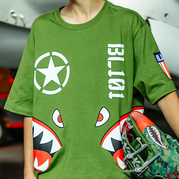 Close up of Army green graphic T-Shirt with shark mouth print, military star emblem, BL101 armor logo on sleeve and bold while BL101 lettering on person
