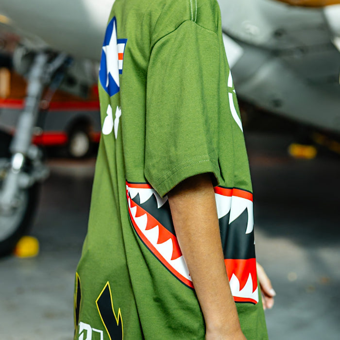 Close up of Army green graphic T-Shirt with shark mouth print, military star emblem, BL101 armor logo on sleeve and bold while BL101 lettering on person