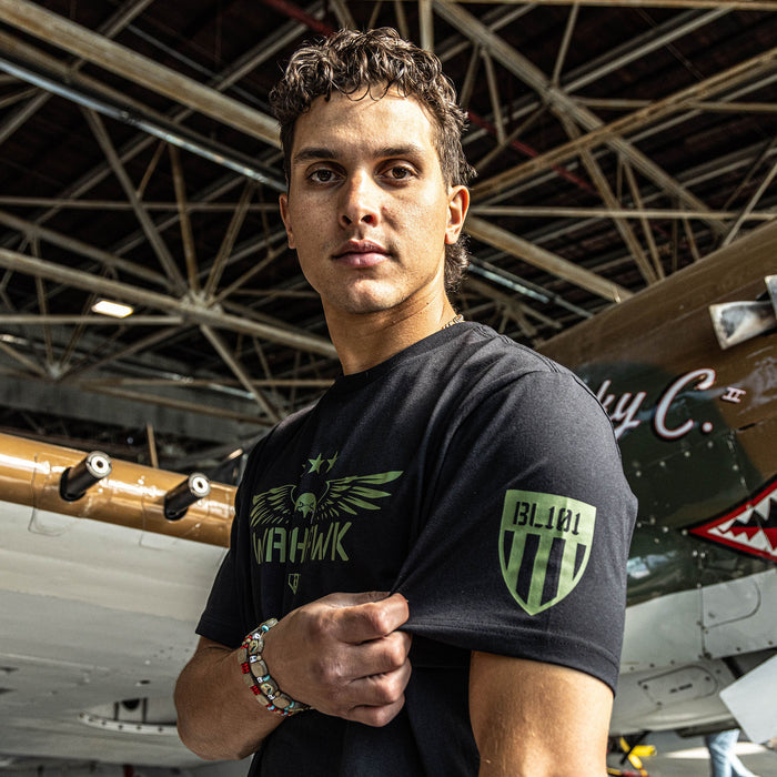 Black t-shirt featuring an army green eagle graphic with green “WARHAWK” lettering and a green Armor BL101 logo on person